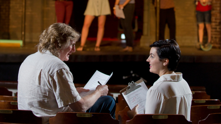 Dramatic writing professor advising student Professor and student in theater studying script