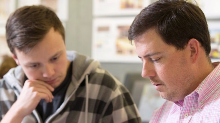 SCAD professor advising student SCAD professor reviewing work with student