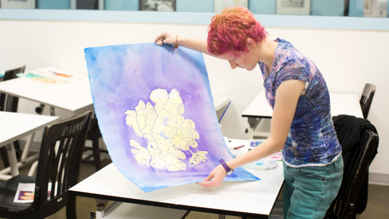 Summer Seminars student painting with watercolor Summer Seminars student holding watercolor painting