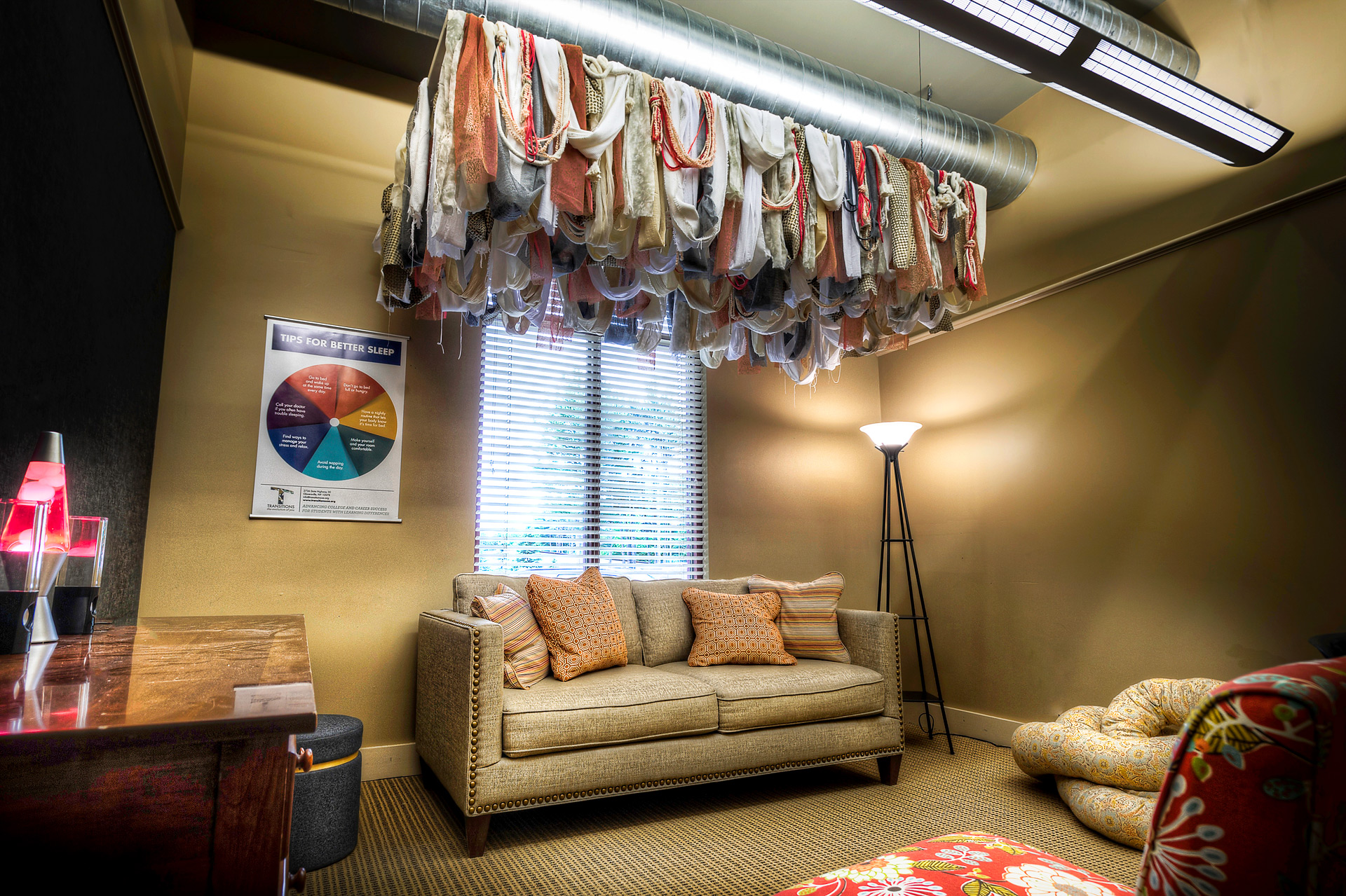 Room with fabric installation above a beige couch