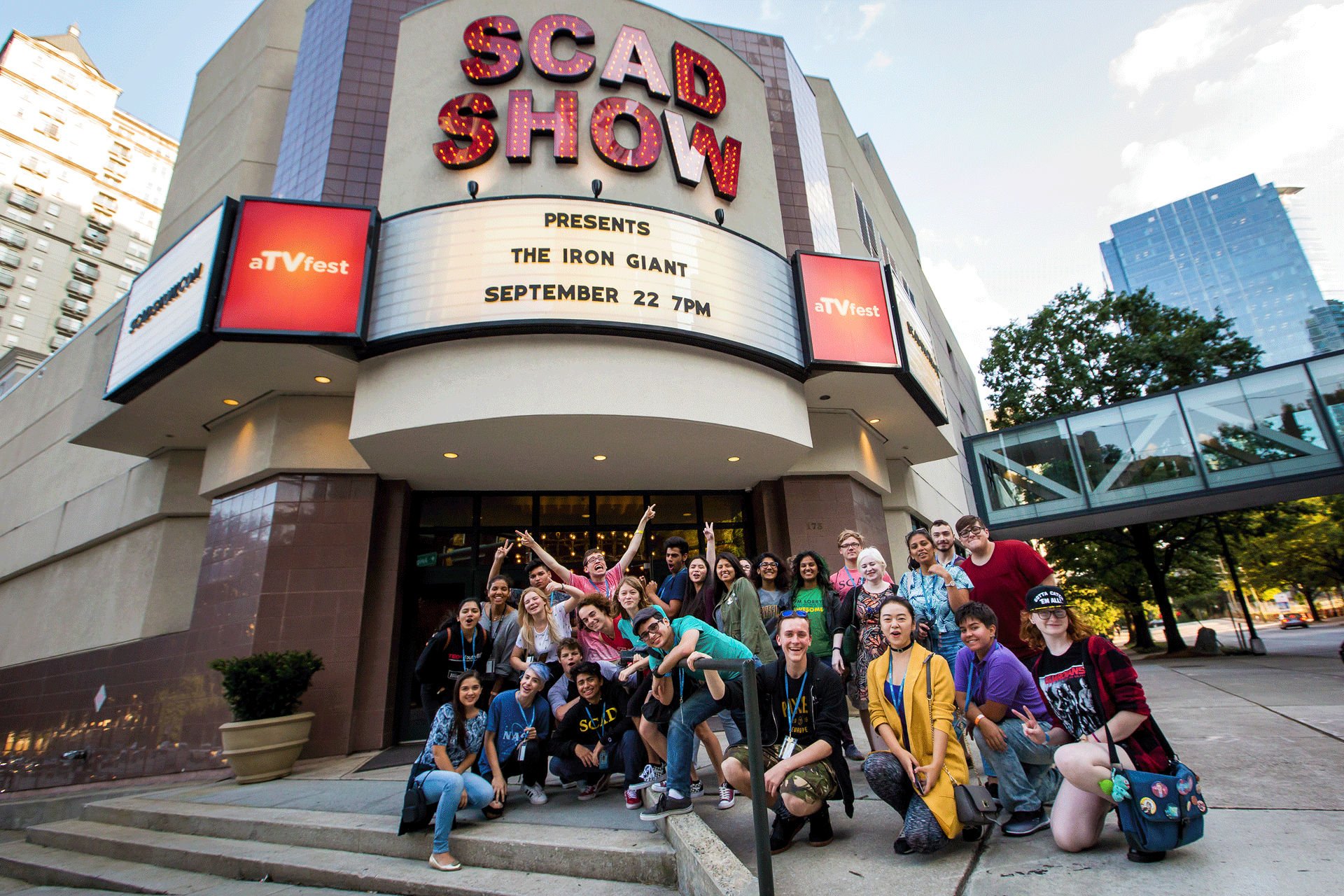 SCAD students gather in front of Atlanta theater cheering and raising their hands