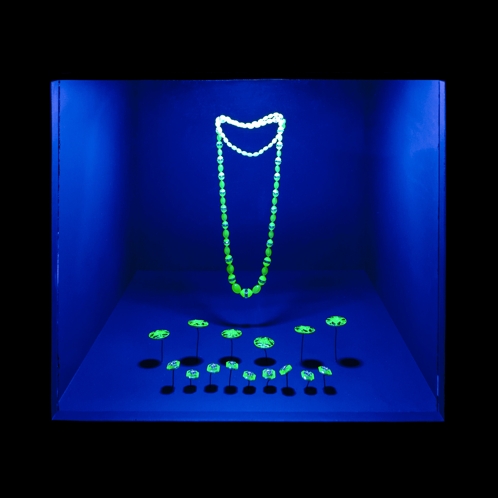 Glowing green necklace and buttons at SCAD Fash exhibition