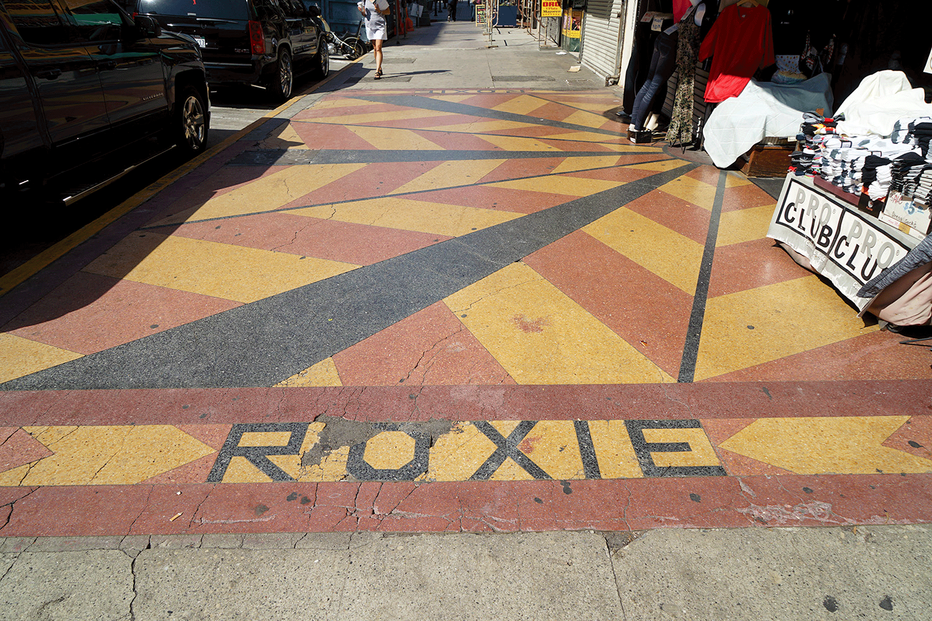 Red, yellow and black sidewalk in blocks with the word roxie 