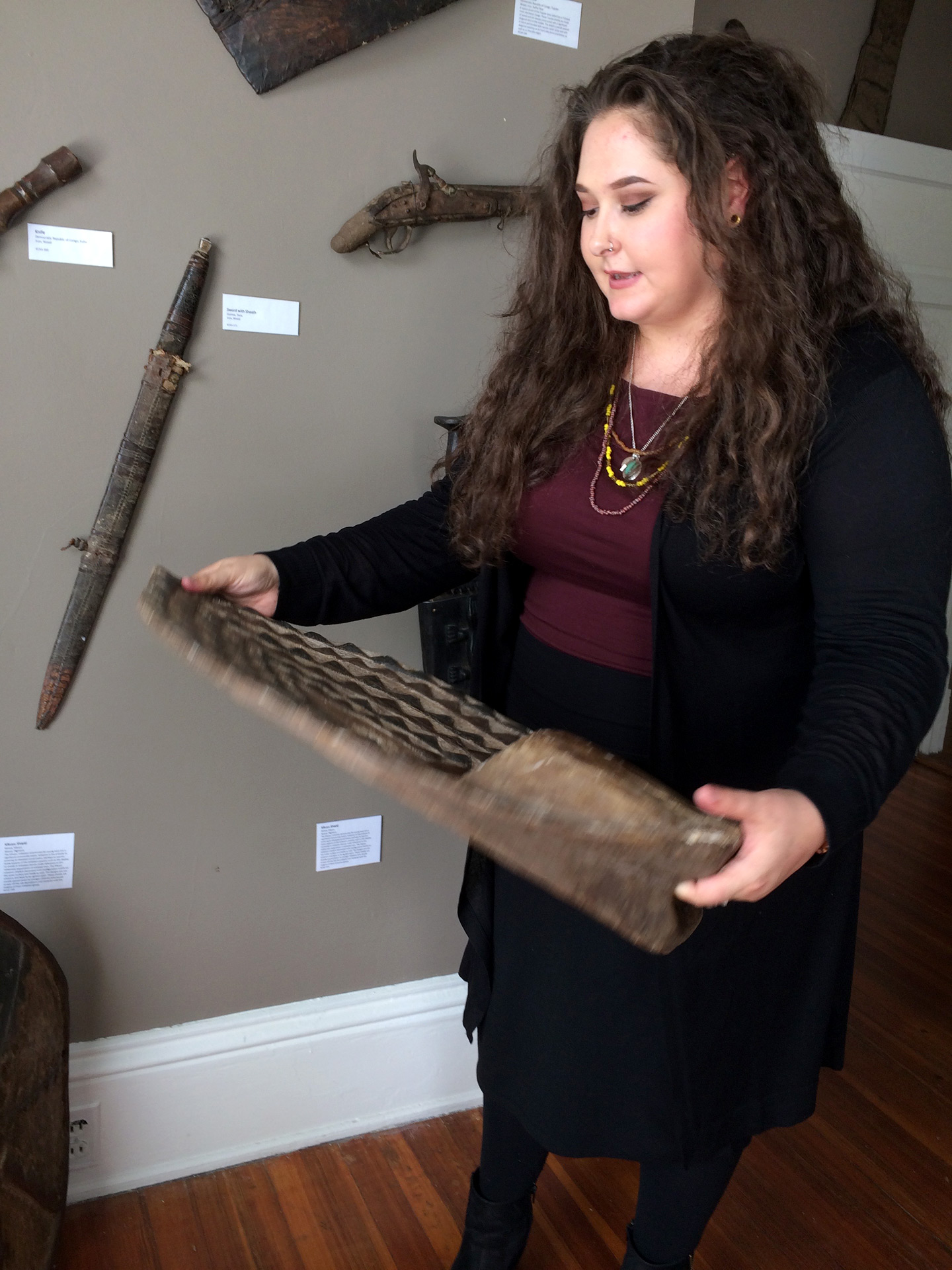 Curator holds artifact in gallery