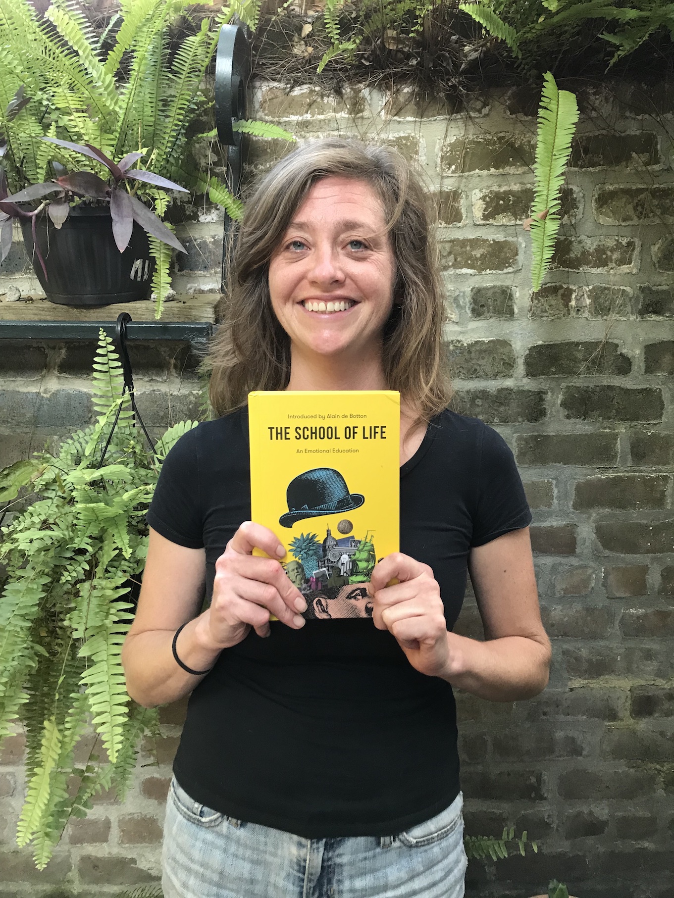 Katie Glusica holding the book, "The School of Life"