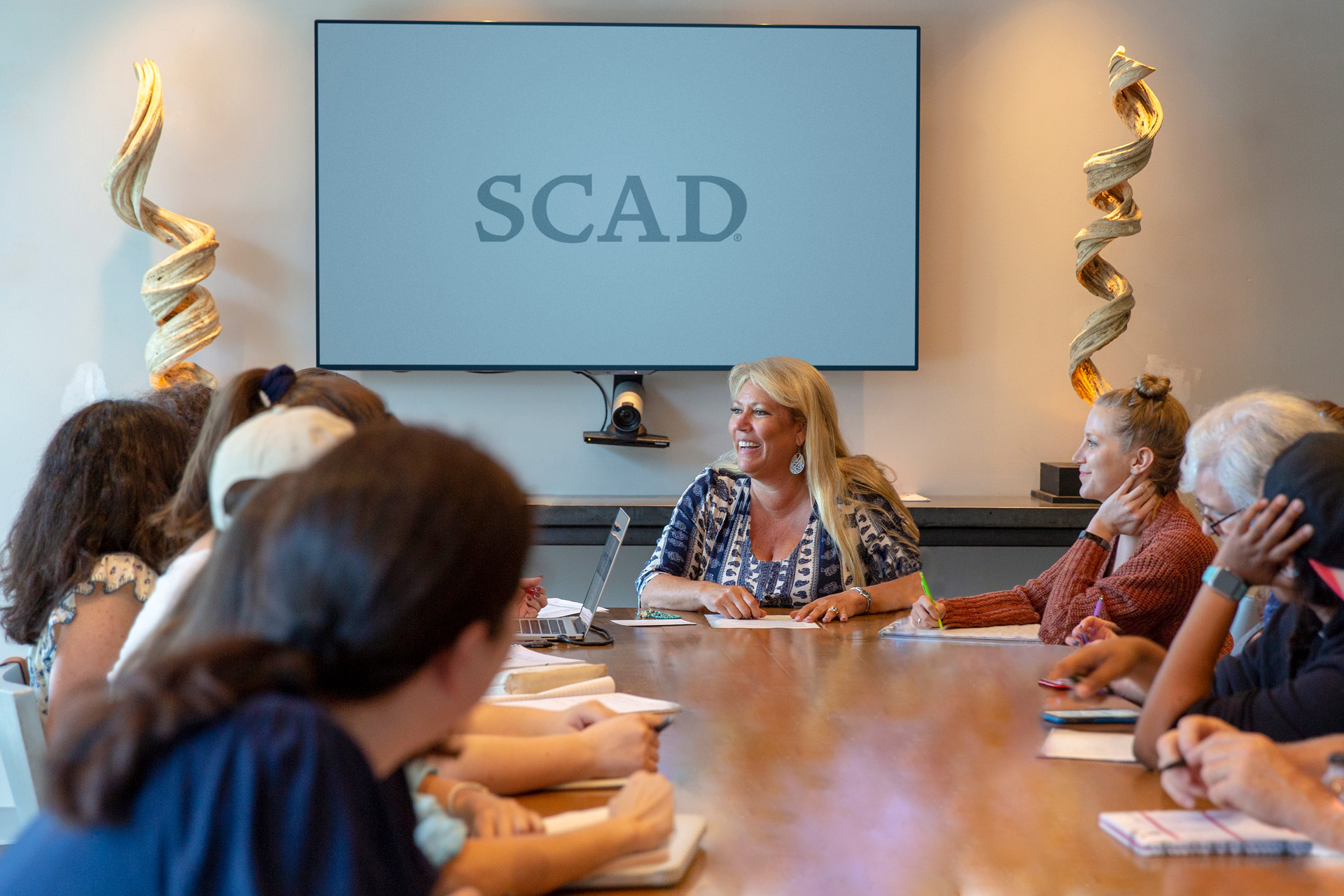 McCullah talks at head of a full conference table