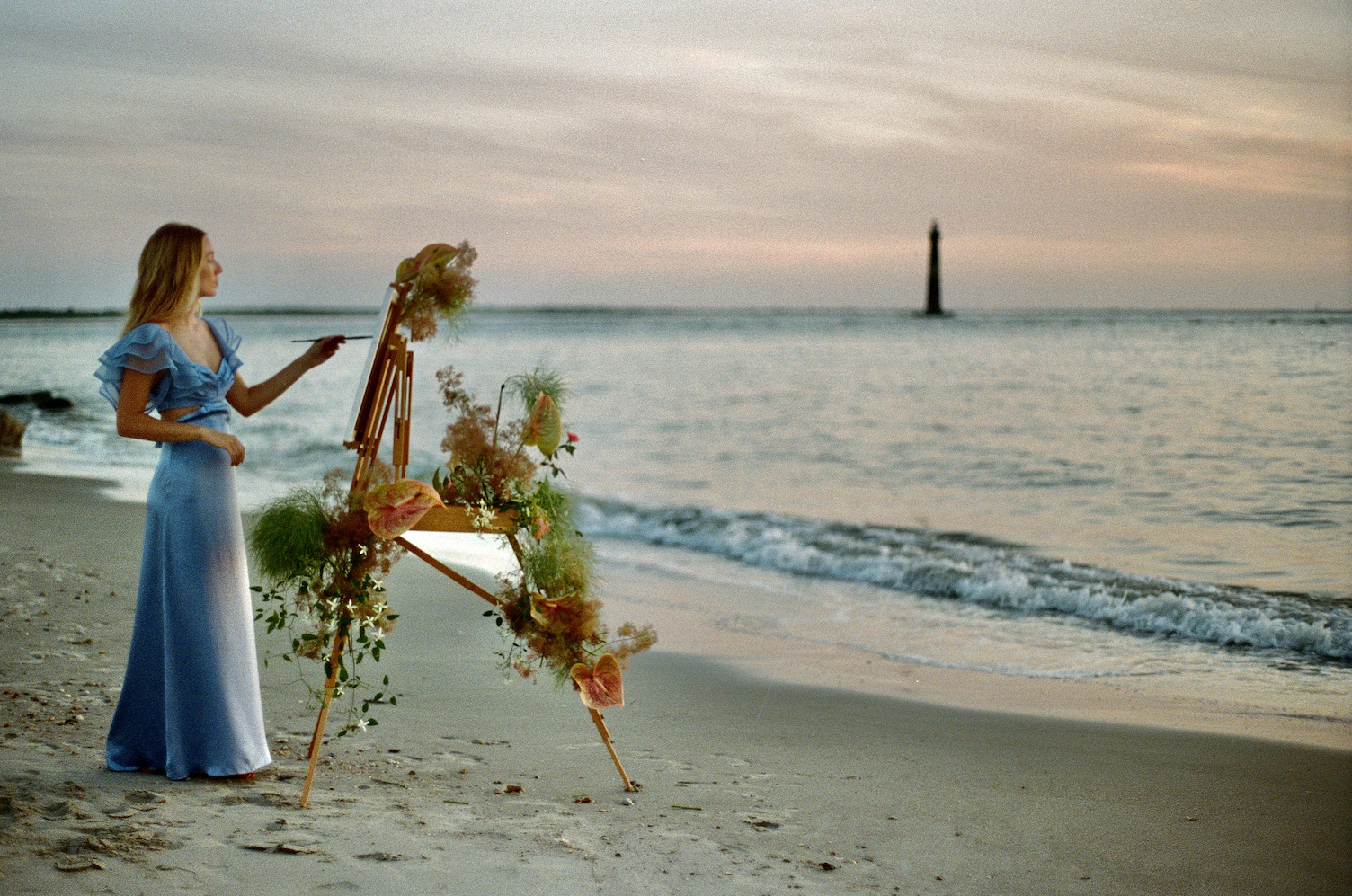 portrait of chloe campbell painting by the ocean at sunset