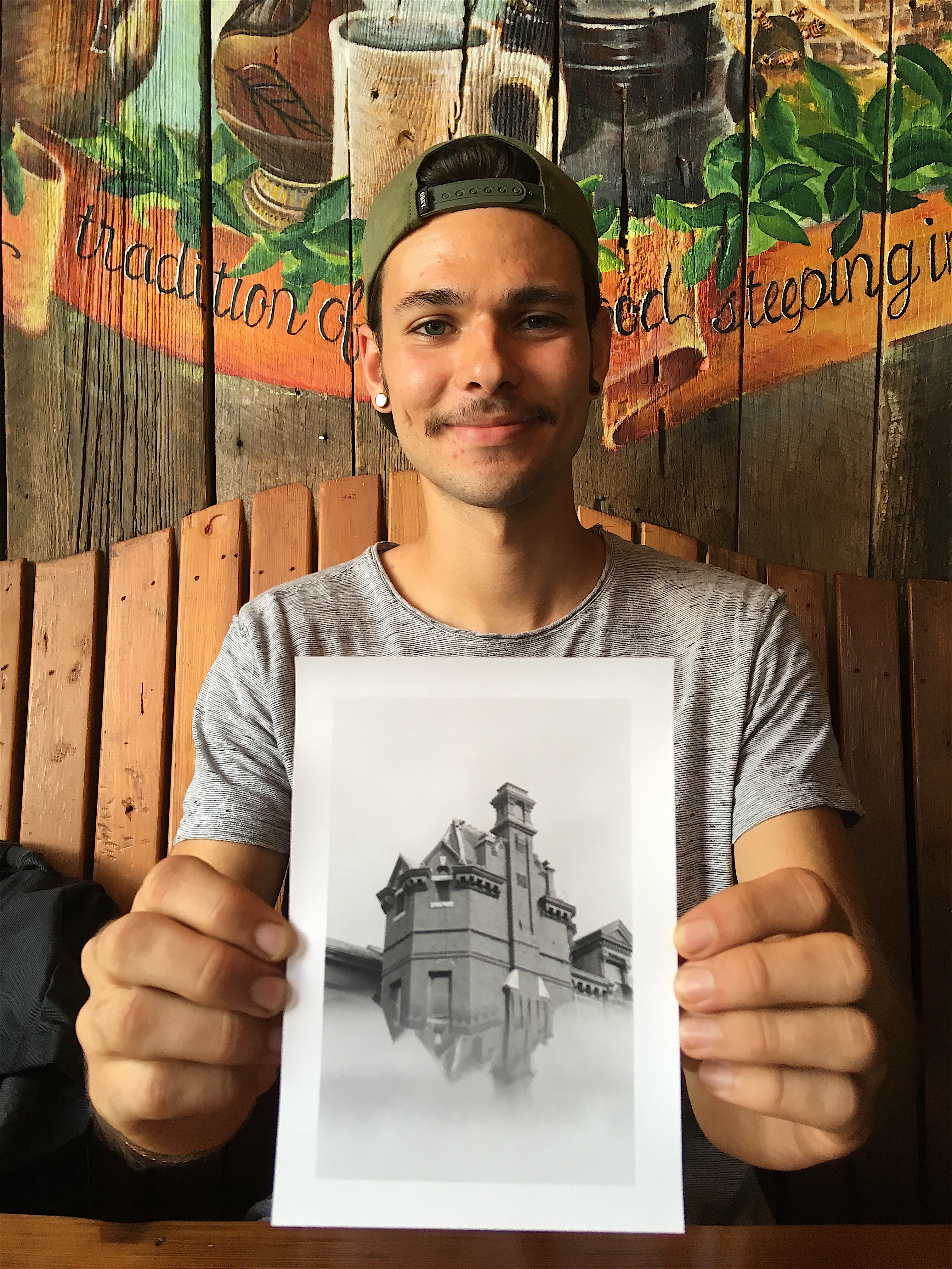 Coleman Camp holds out one of his black and white images