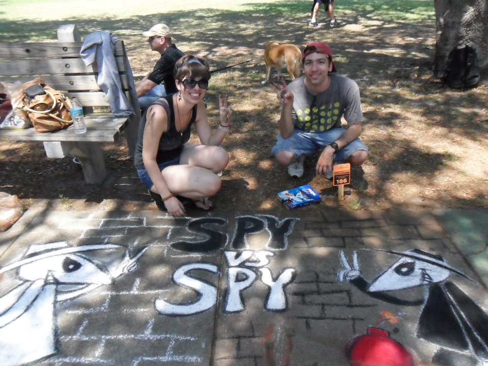 Two SCAD students work on a Spy vs. Spy sidewalk chalk artwork