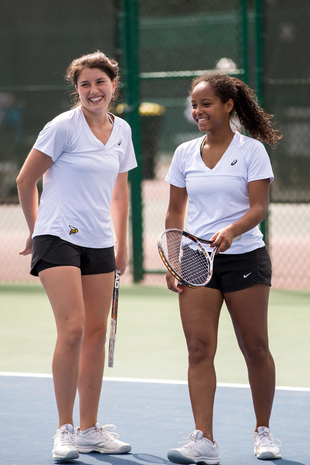 Tennis players in matching white shirts and black shorts