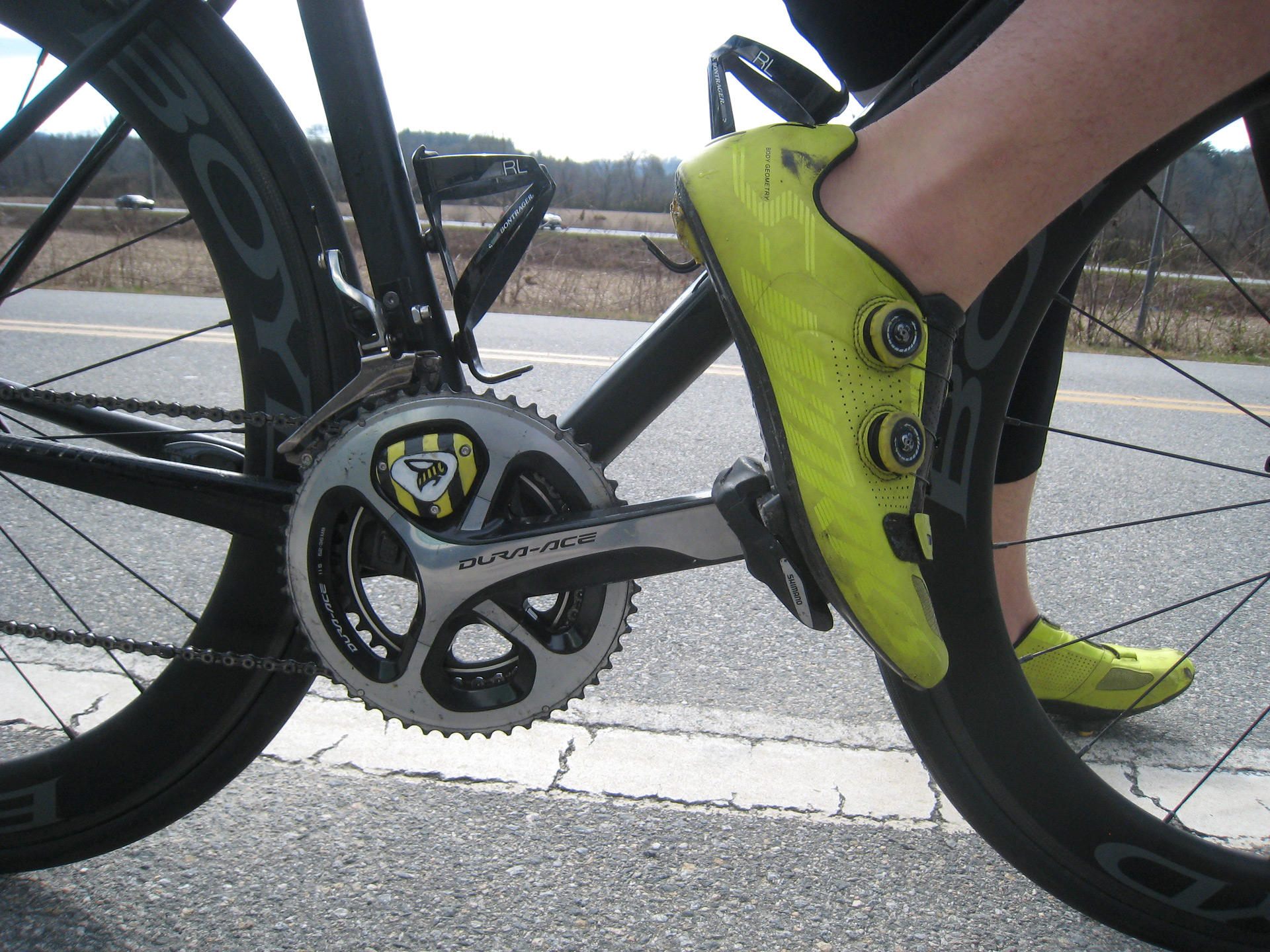 Close up of bicycle pedals with neon cycling shoes
