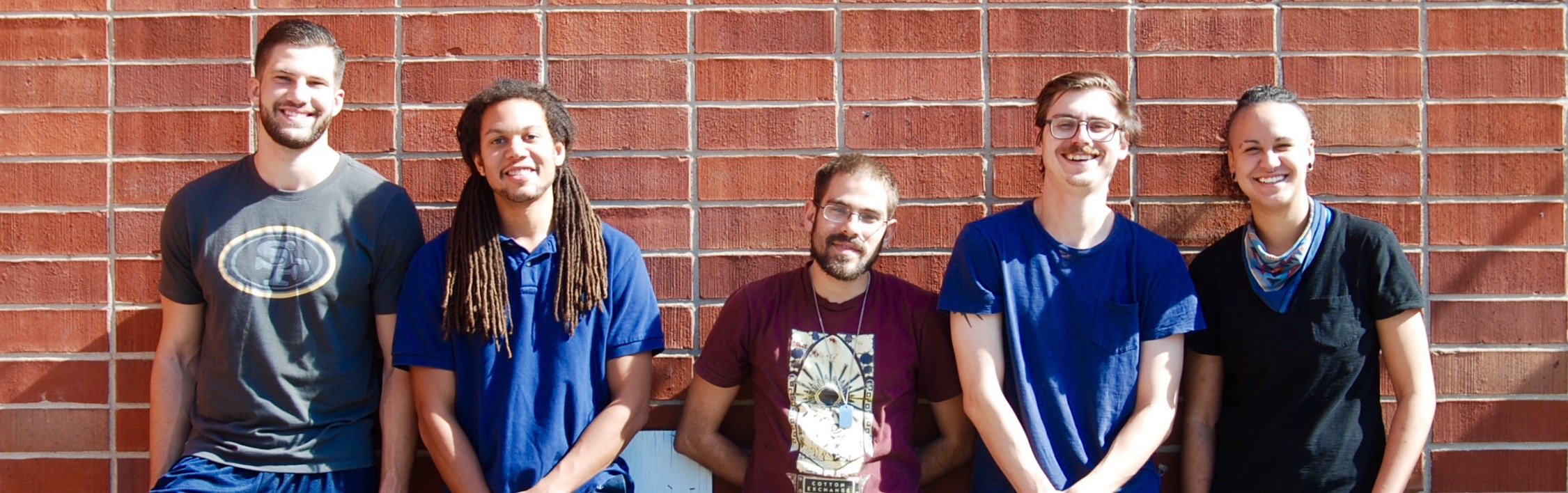 Five members of 13 Bricks lined up against a brick wall