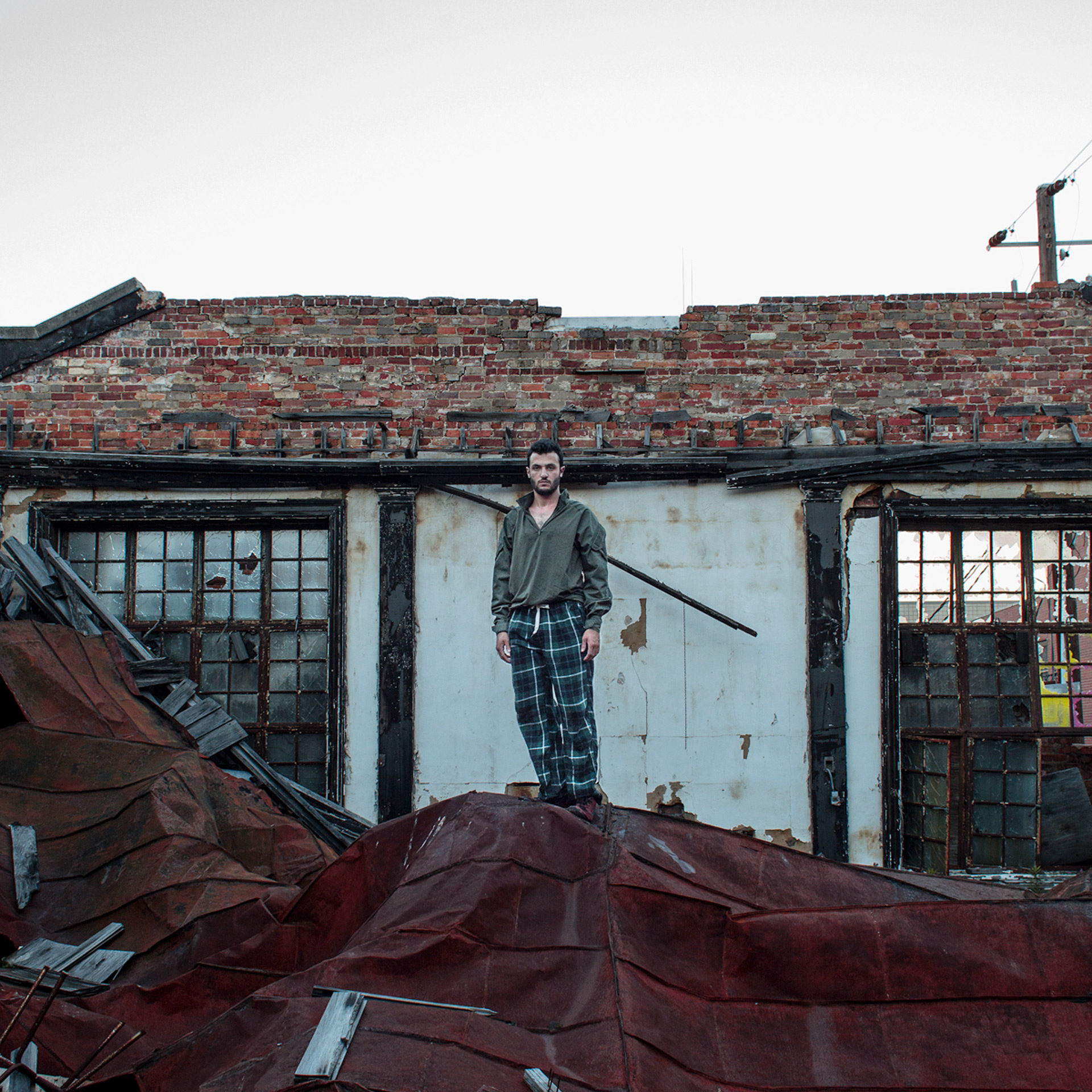 Joey Katz stands on mound of debris