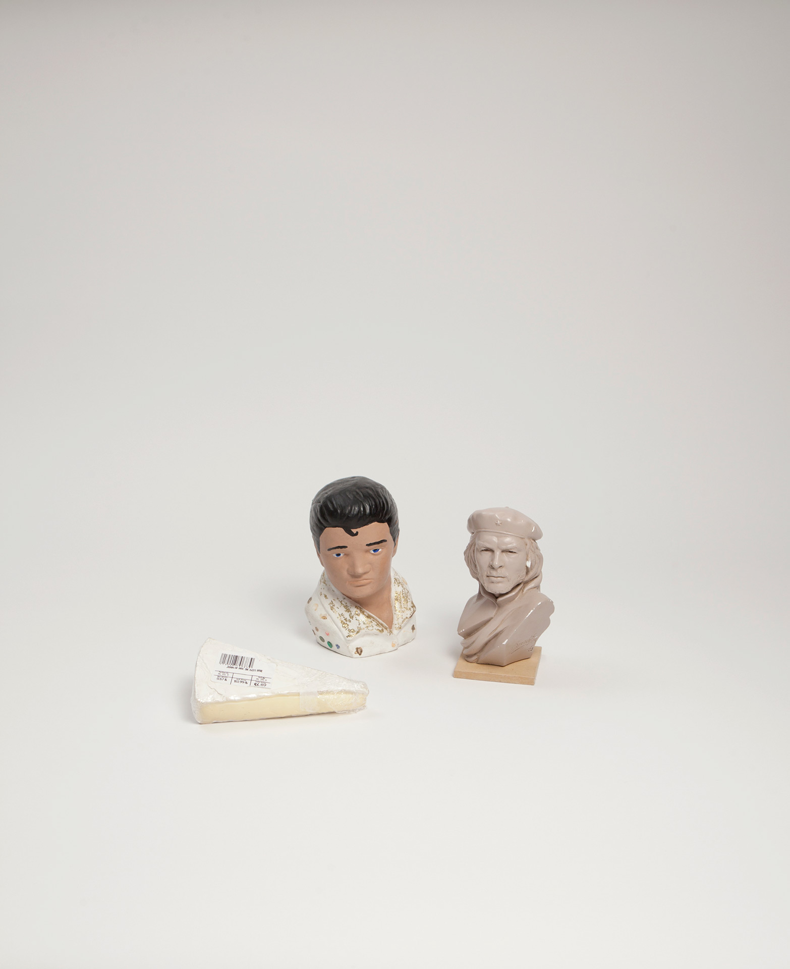 Miniature busts of Elvis Presley and Che Guevara with a slice of Brie