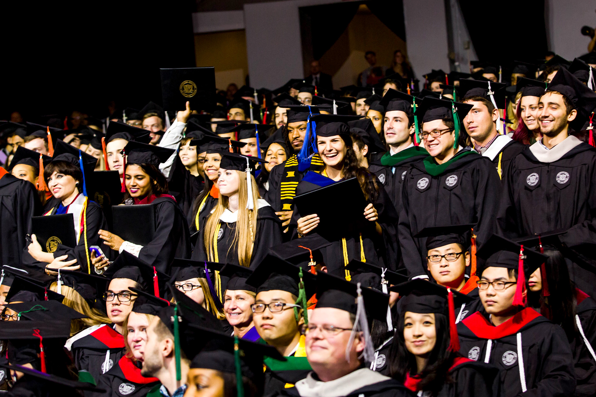 Graduates in cap and gown look on