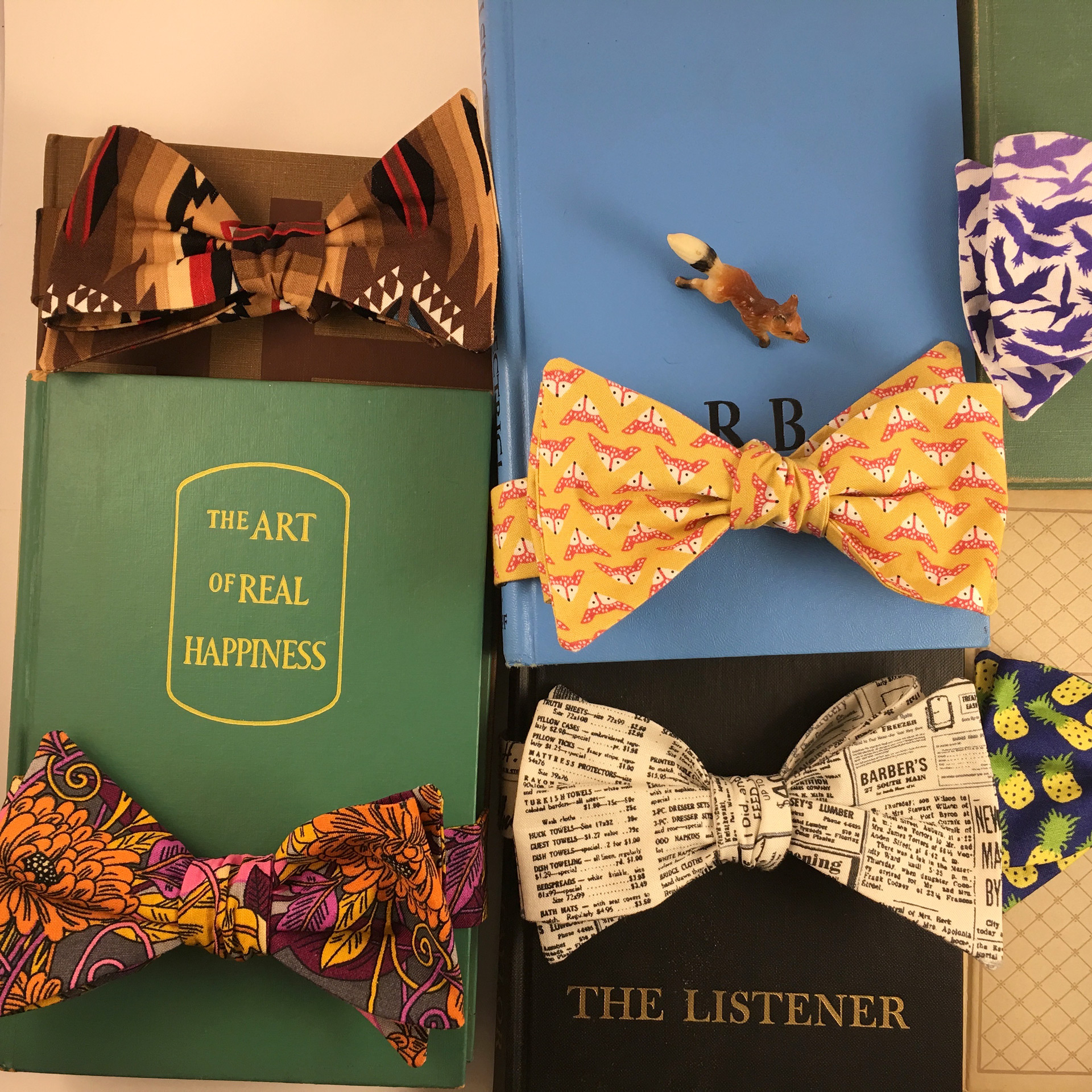 Bowties in vibrant prints nestled amongst books