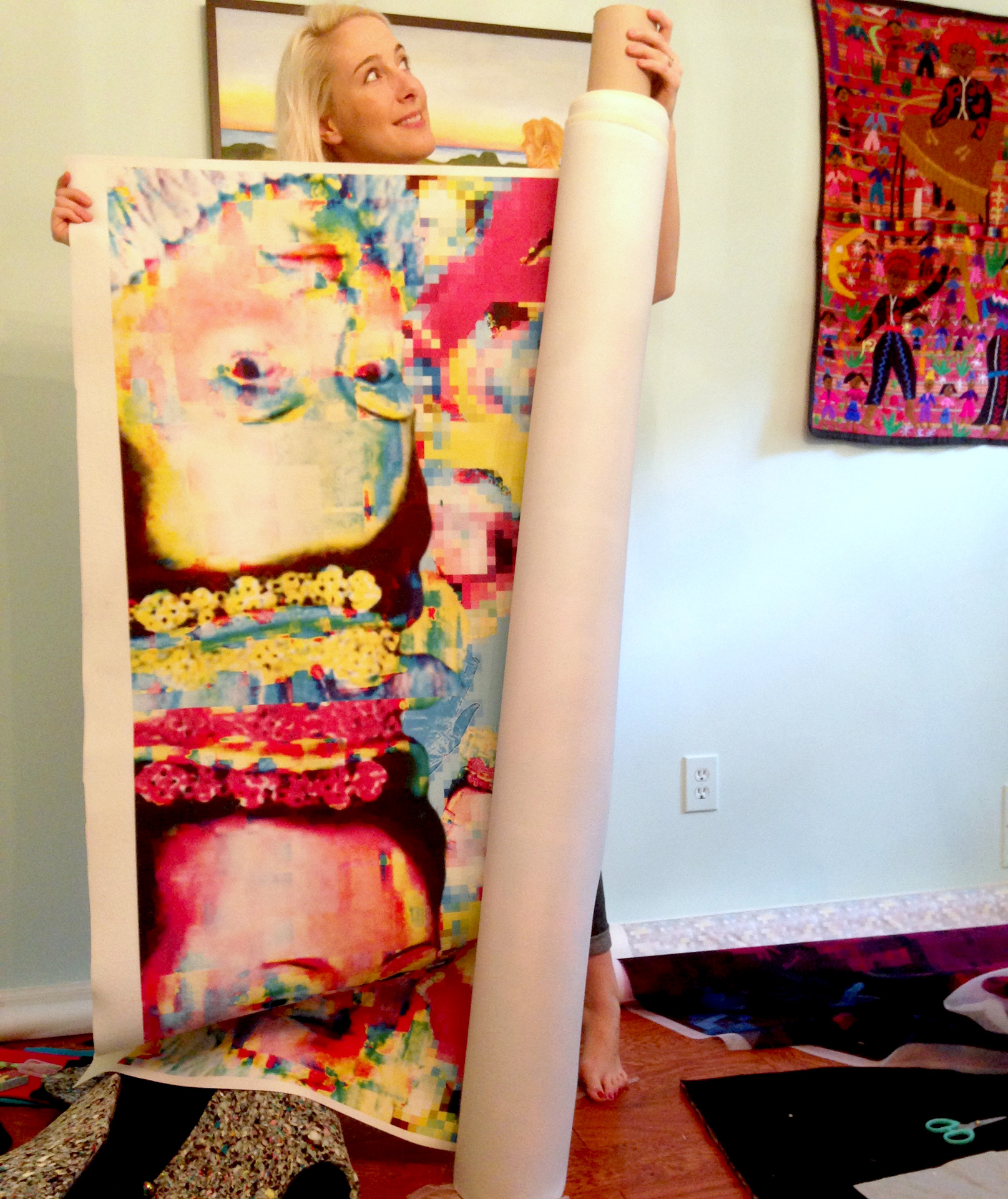 Leah Rama holds a roll containing a portion of her mural
