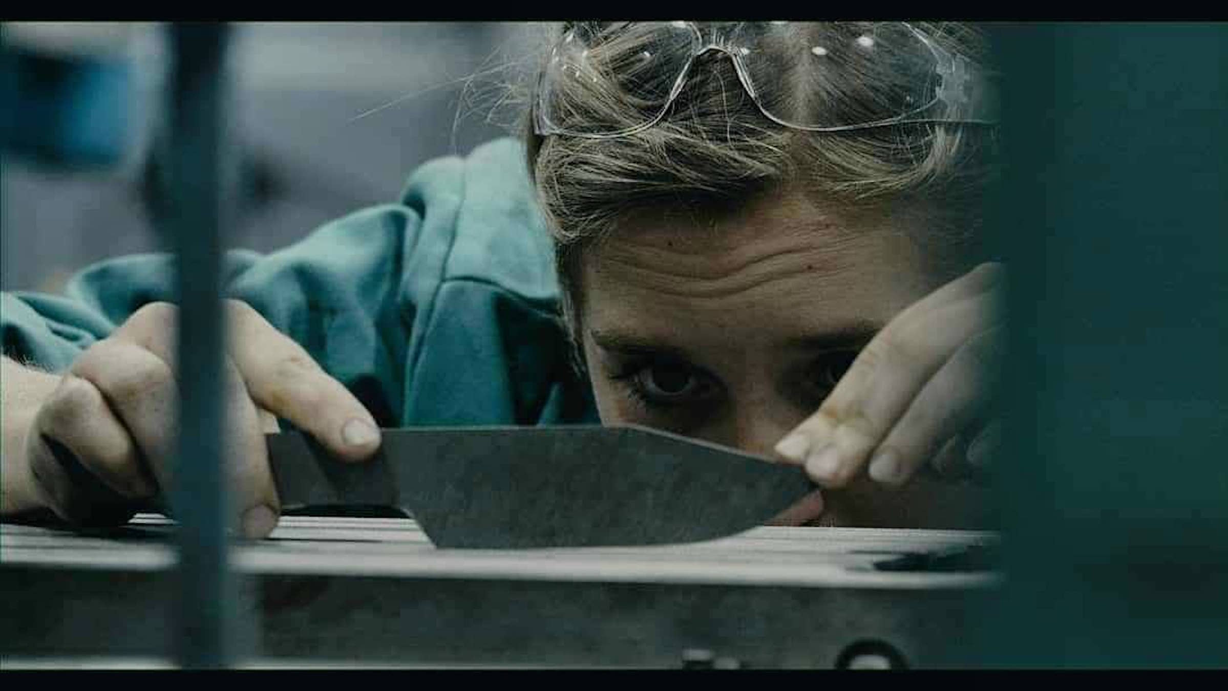 Student looks closely at hand-hewn knife 