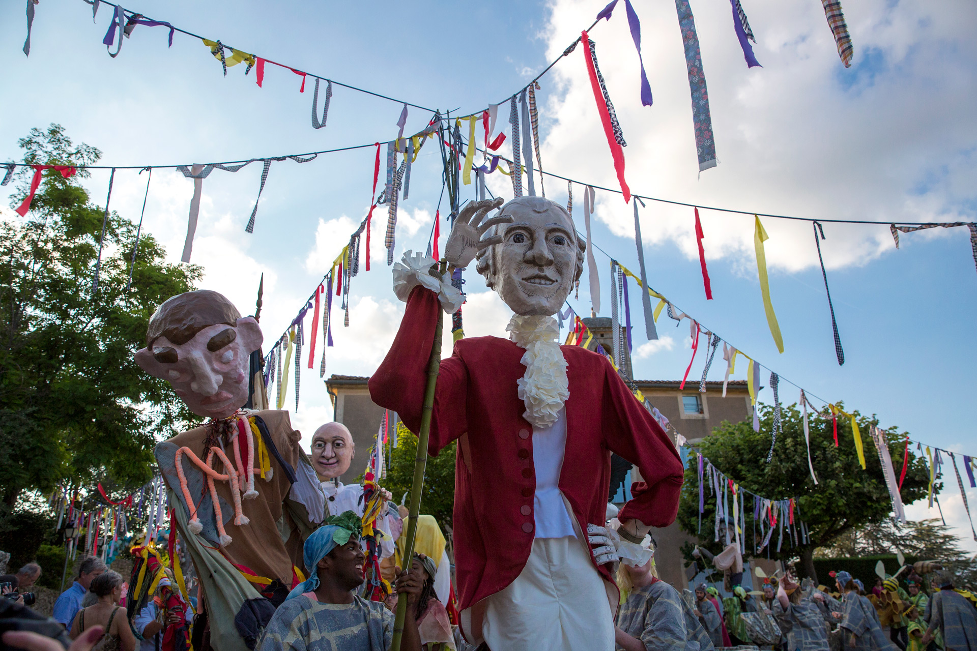 Large puppets held up in Lacoste celebration