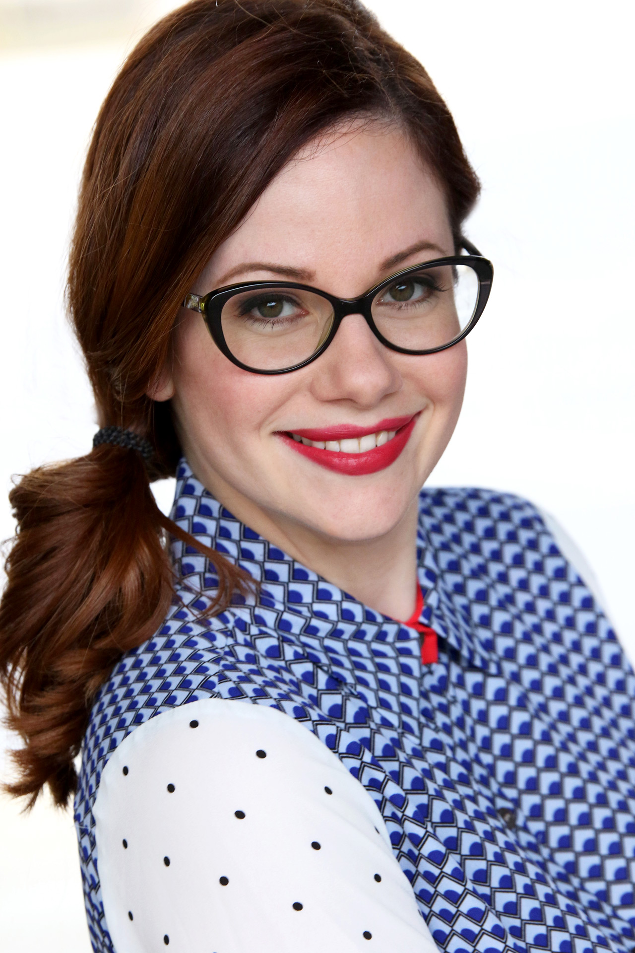 Pike with black glasses and blue blouse smiles