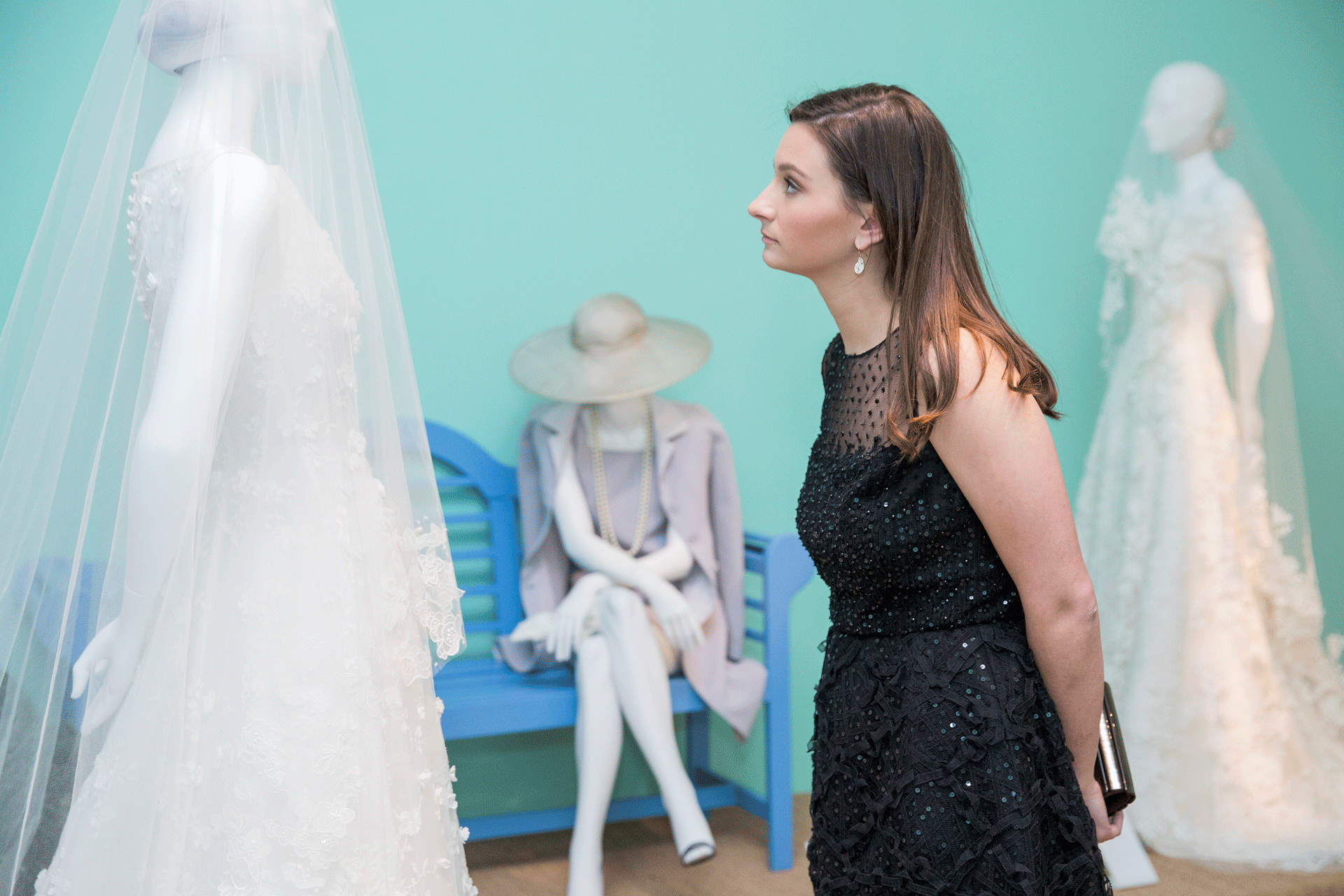 Woman takes a closer look at a white Oscar de la Renta wedding dress on display at SCAD Museum of Art