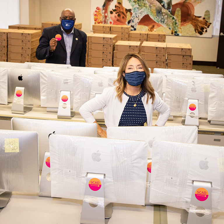 SCAD President and Founder Paula Wallace helps prepare new computers for donation