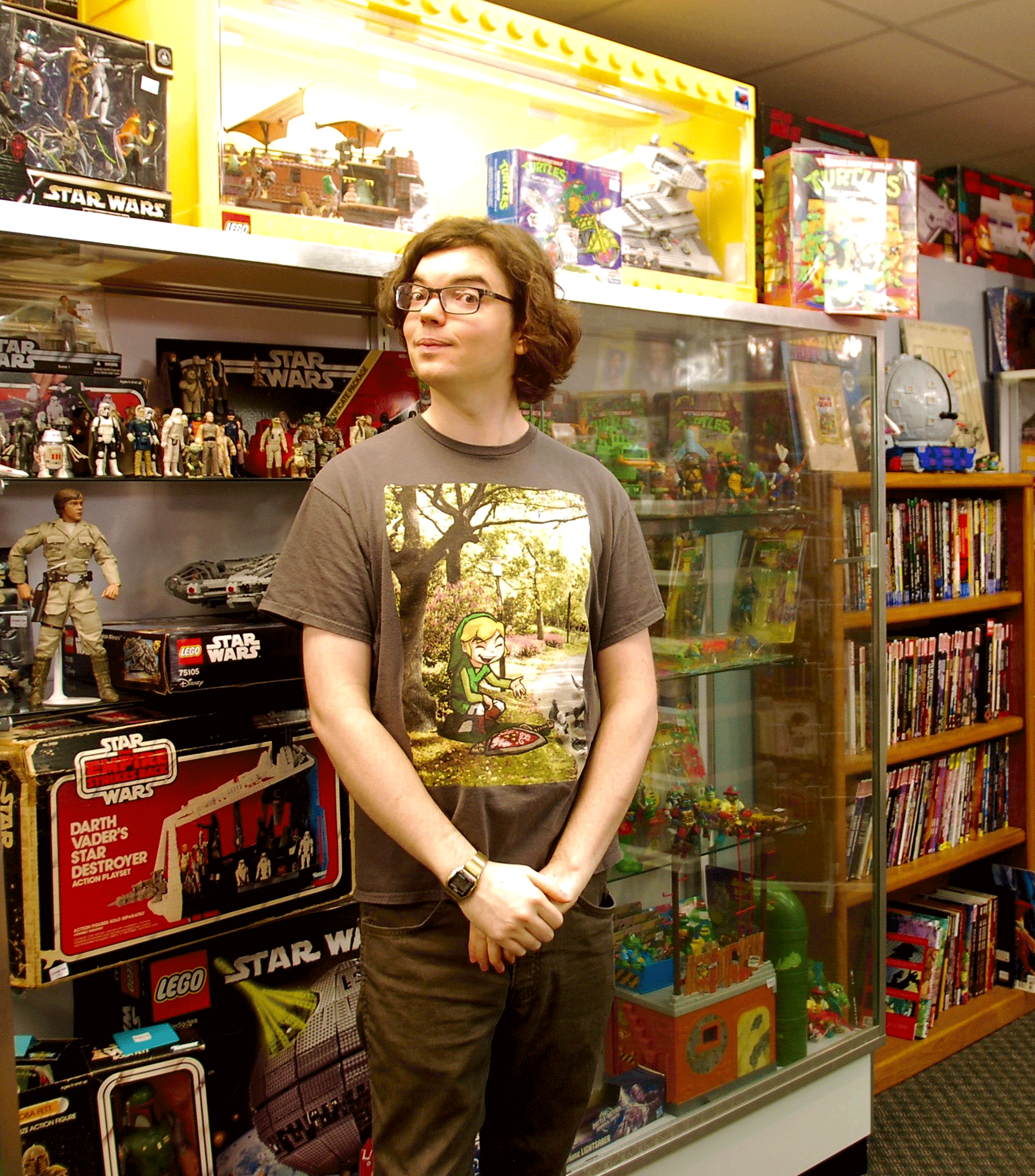 John Croley stands inside his store Planet Fun in front of shelves of toys and figurines