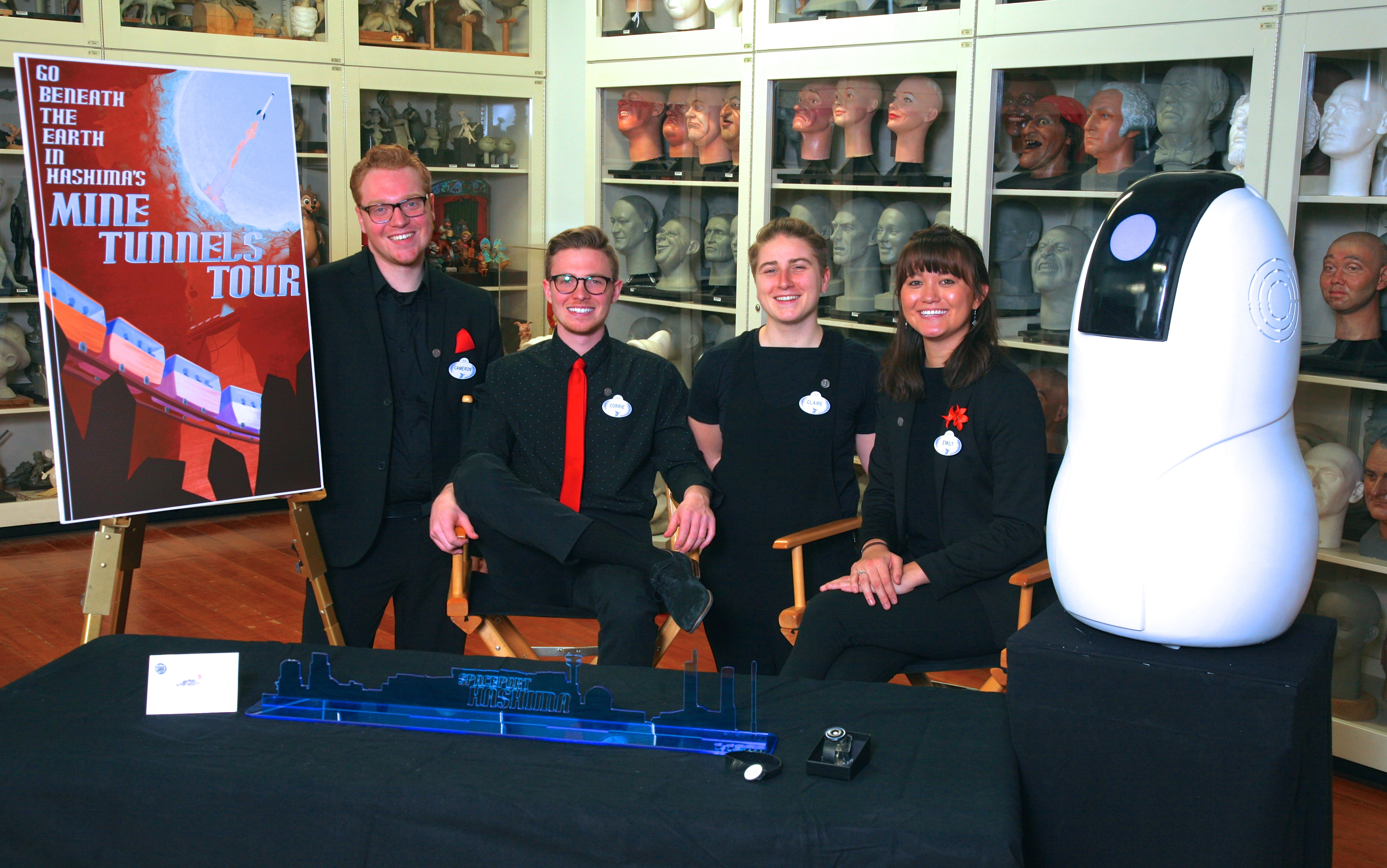 Students stand next to their winning project mine tunnels tour displayed on a table 