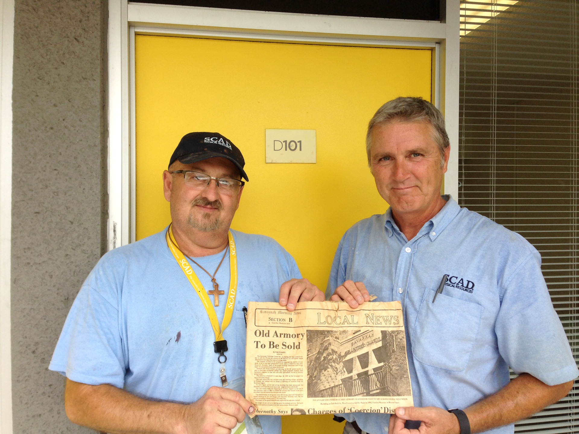 Two SCAD staff hold newspaper