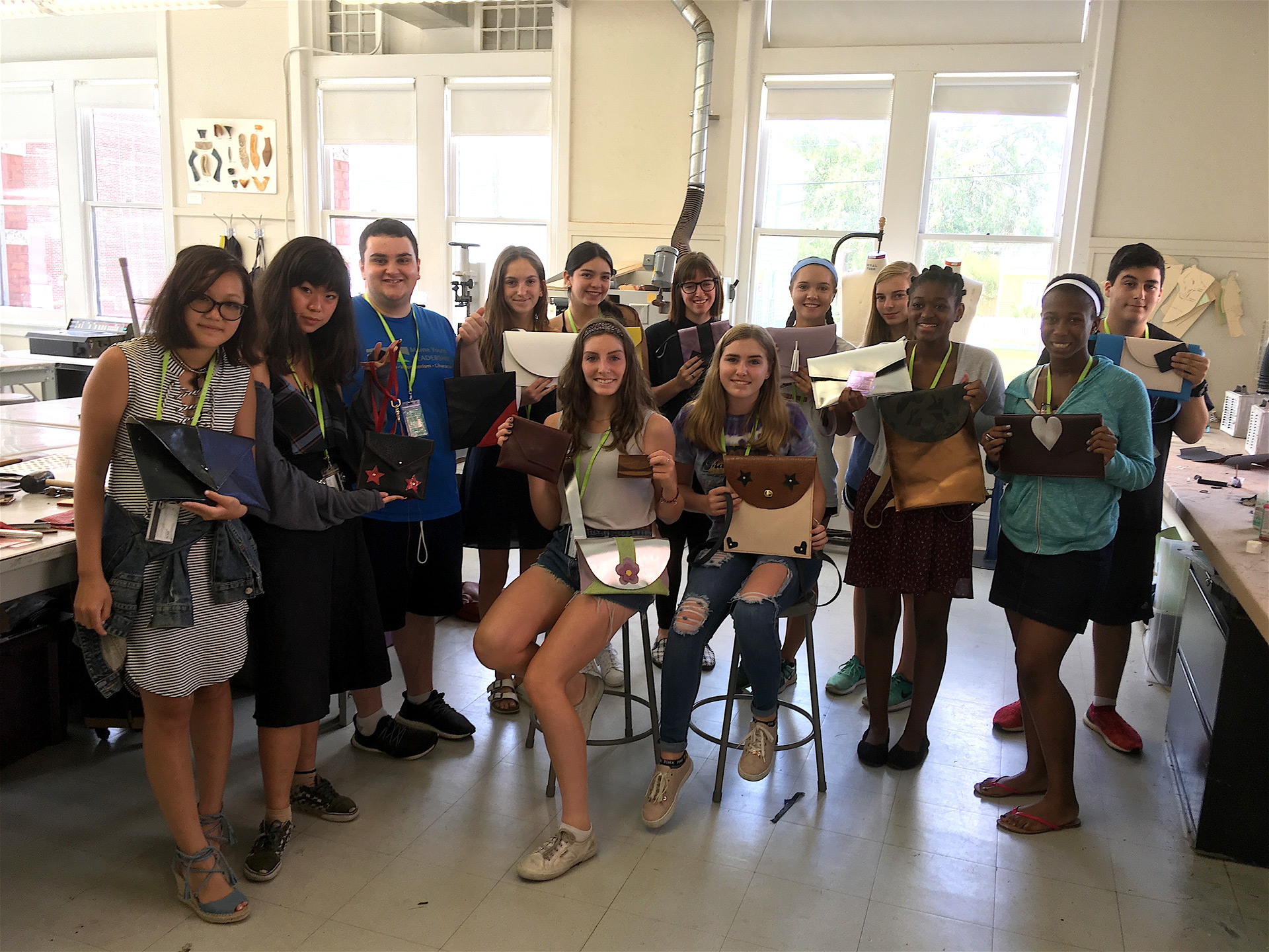 Group of students show off their handmade leather goods