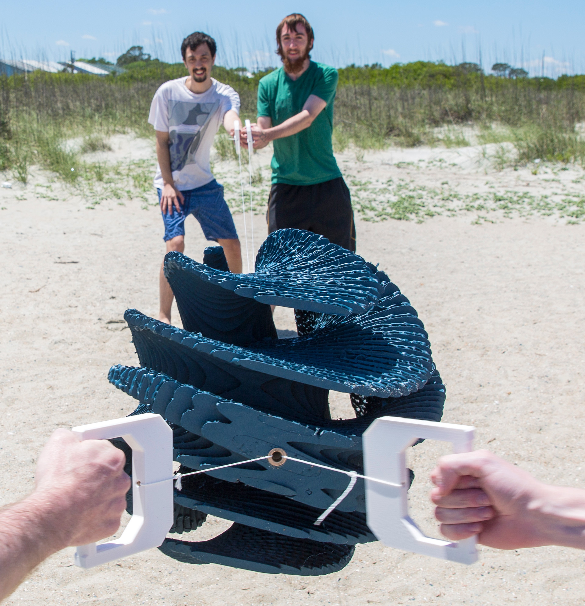 Students hold two ends of a wind sculpture
