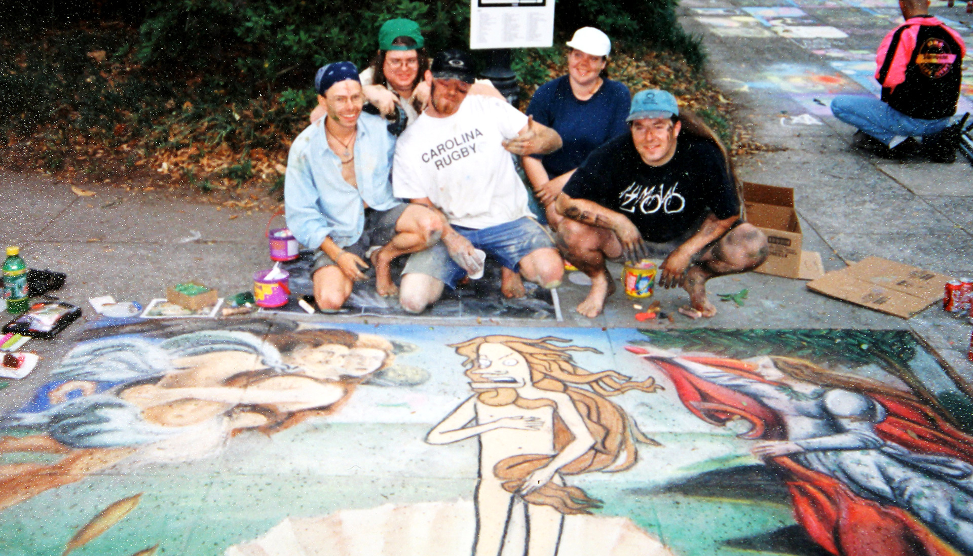 Troy Wingard and friends kneel over their work at the 1997 Sidewalk Arts Festival