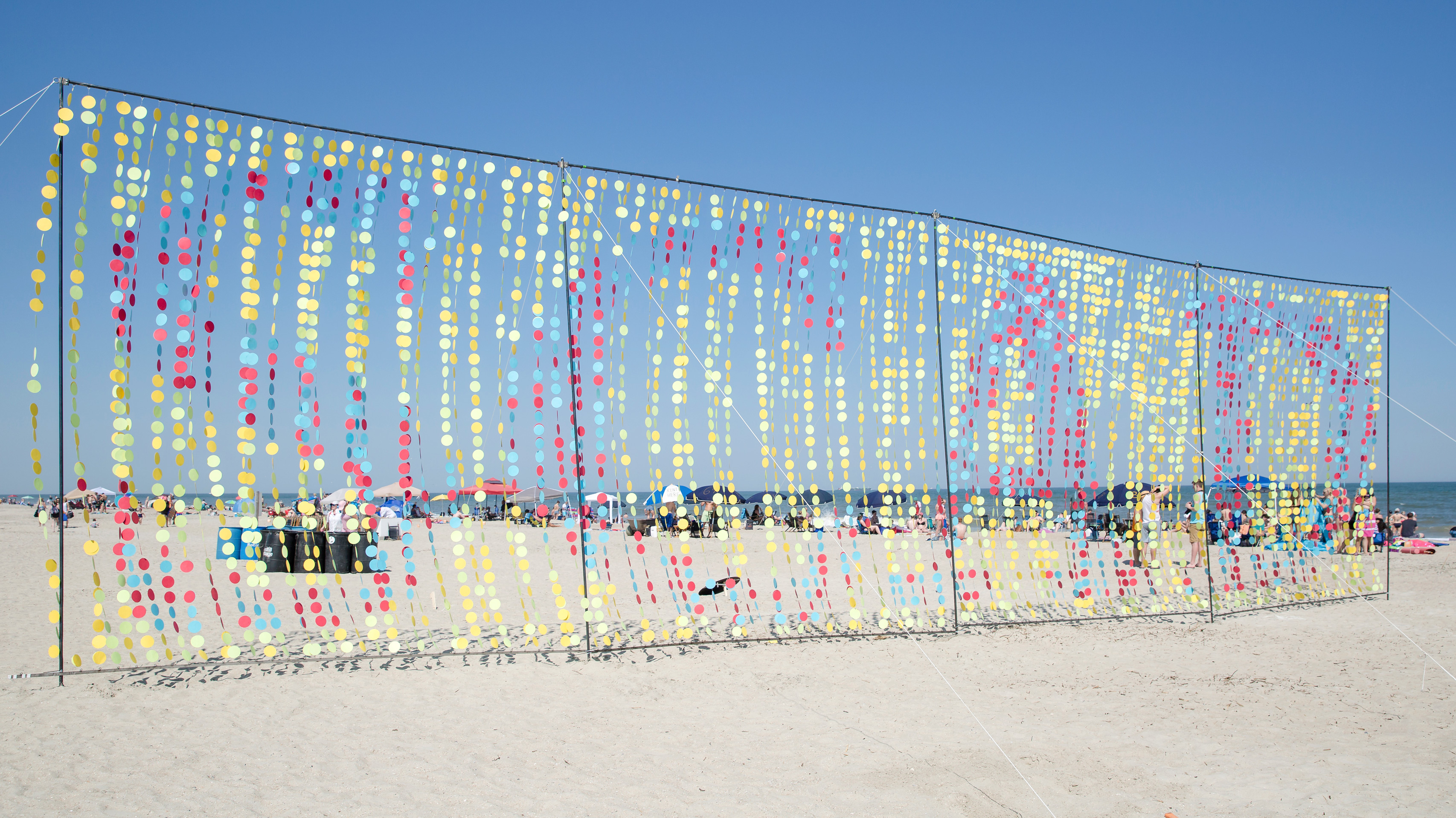 Large wind sculpture made up of colorful dots that spell SCAD