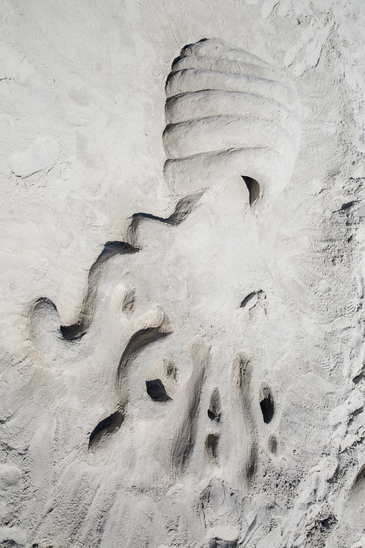 Sand design of octopus tentacles coming out of a beehive 