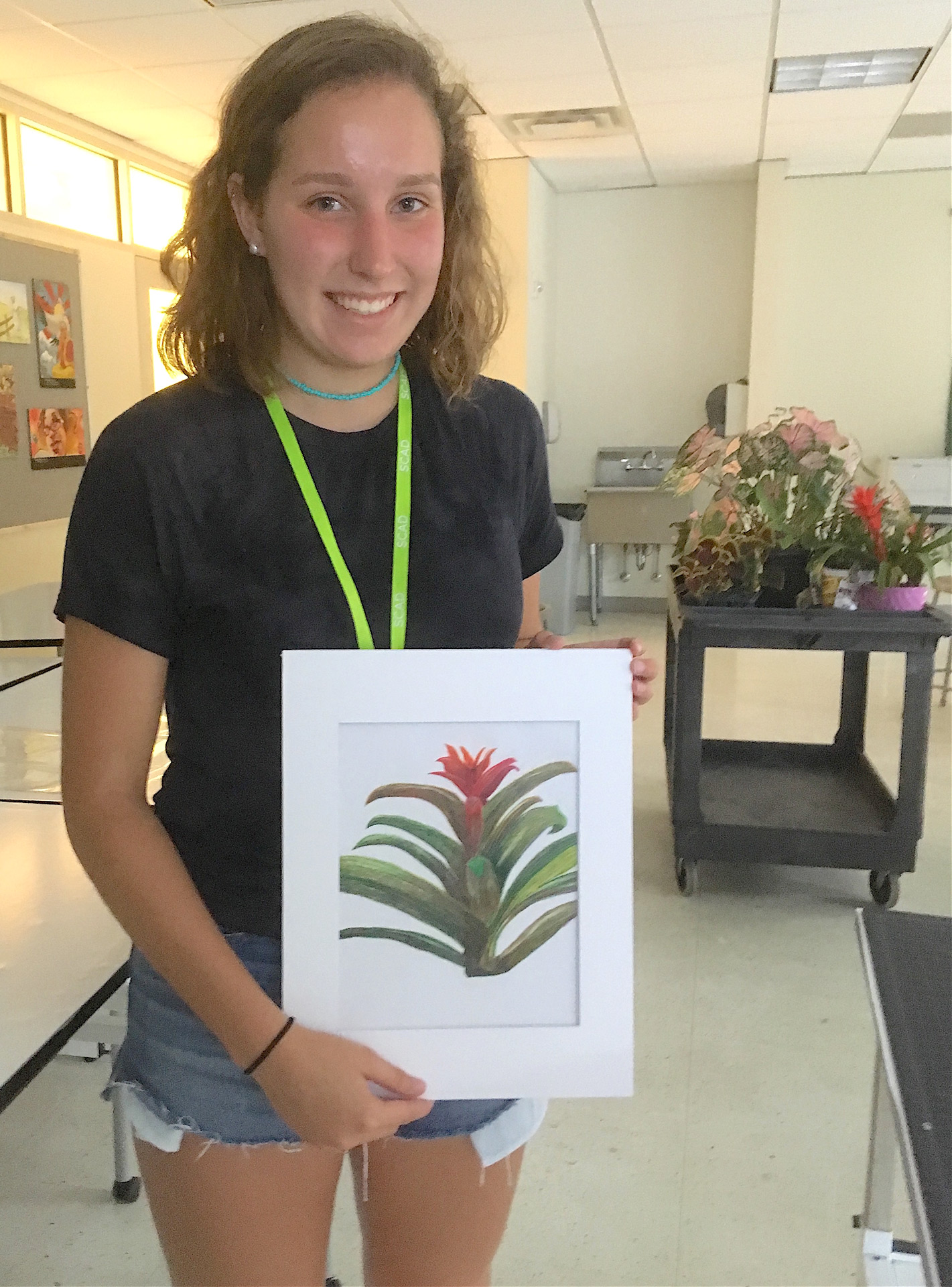 Student shows off framed botanical drawing