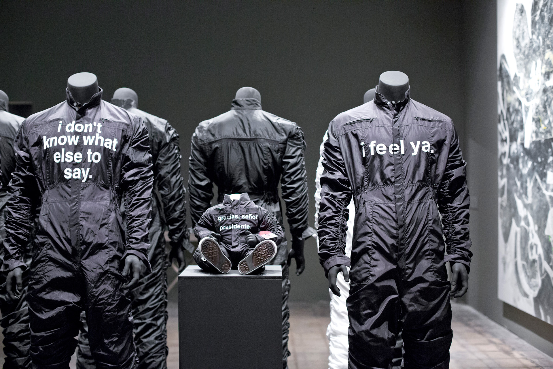 Black jumpsuits on display with different messages written on the chest