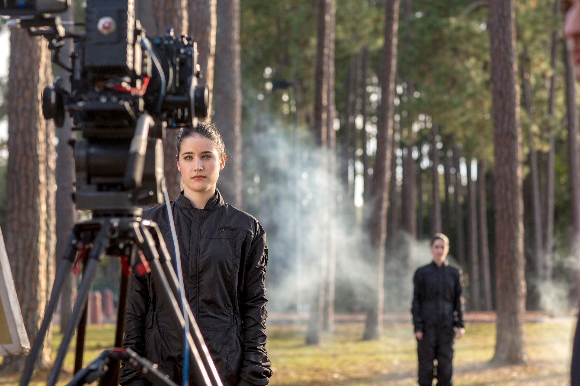 Model in black jumpsuit stands in front of camera