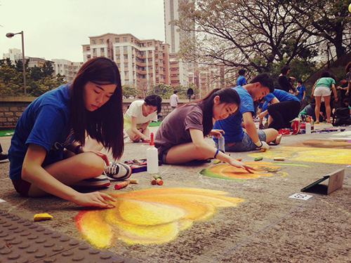 Several students working on their sidewalk artwork