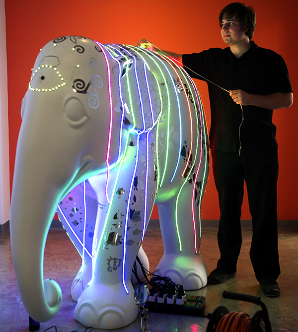Kevin Lee Jr. measures his elephant adorned in neon lighted ropes