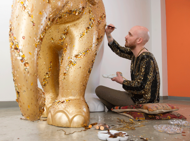 Michael-Birch Pierce applies crystals to his gold elephant