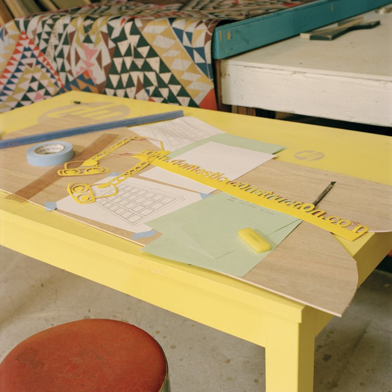 Yellow table with work on top that is in progress