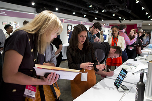 Student shows off her work on tablet to visitor