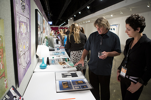 Visitors to the fair examine work on a table