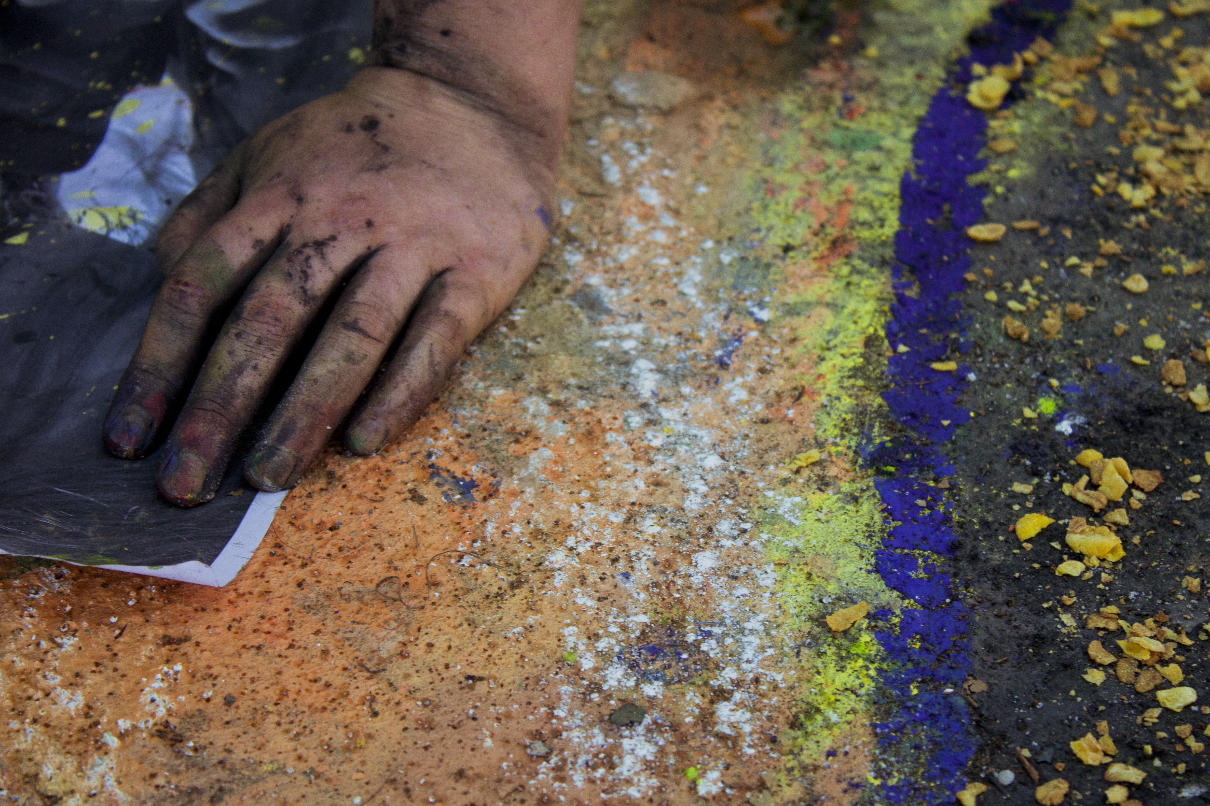 Detail of participant with sandpaper working on their sidewalk chalk artwork