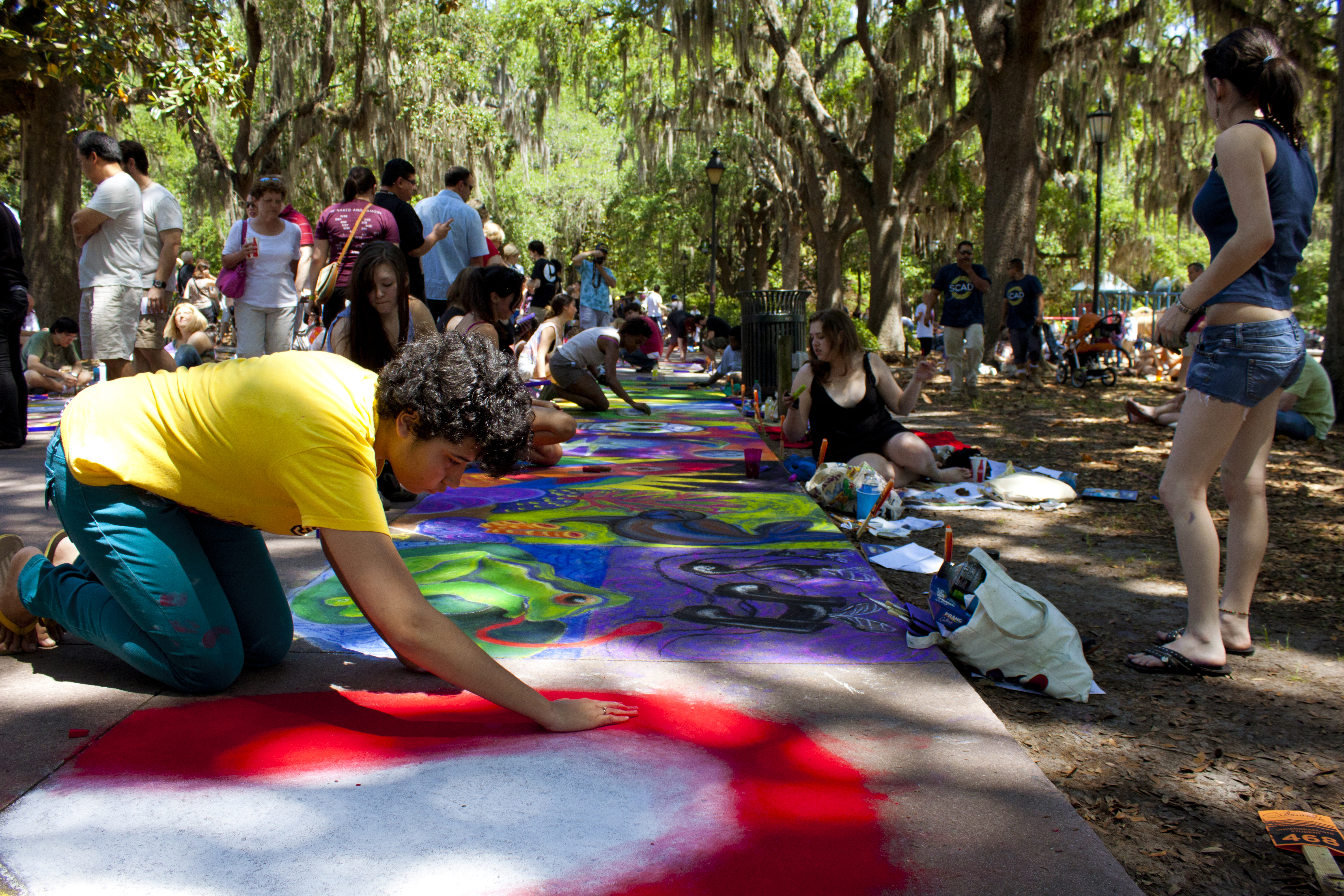 Row of students working on their sidewalk chalk artwork