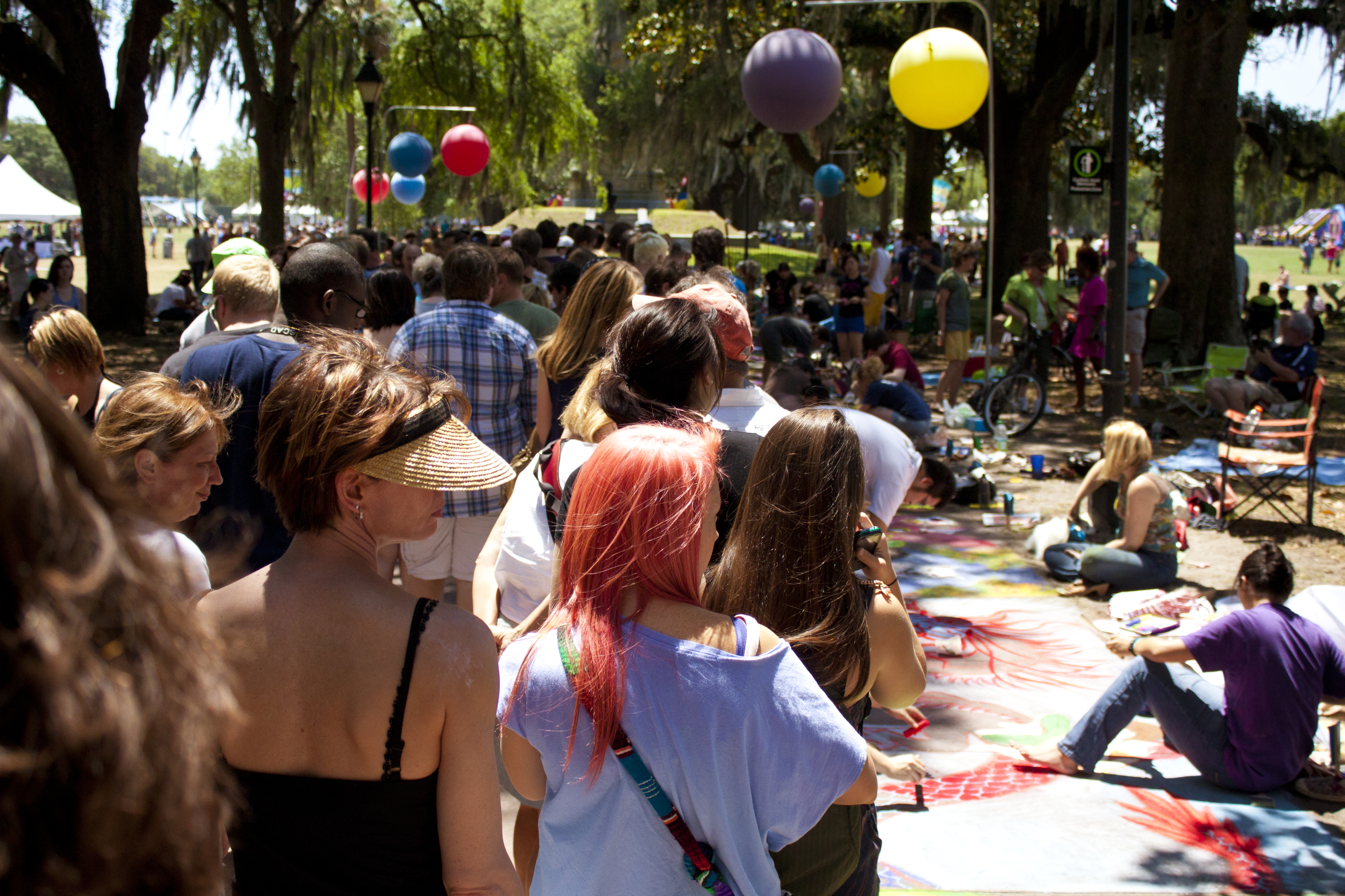 Crowded sidewalk full of visitors looking at artwork