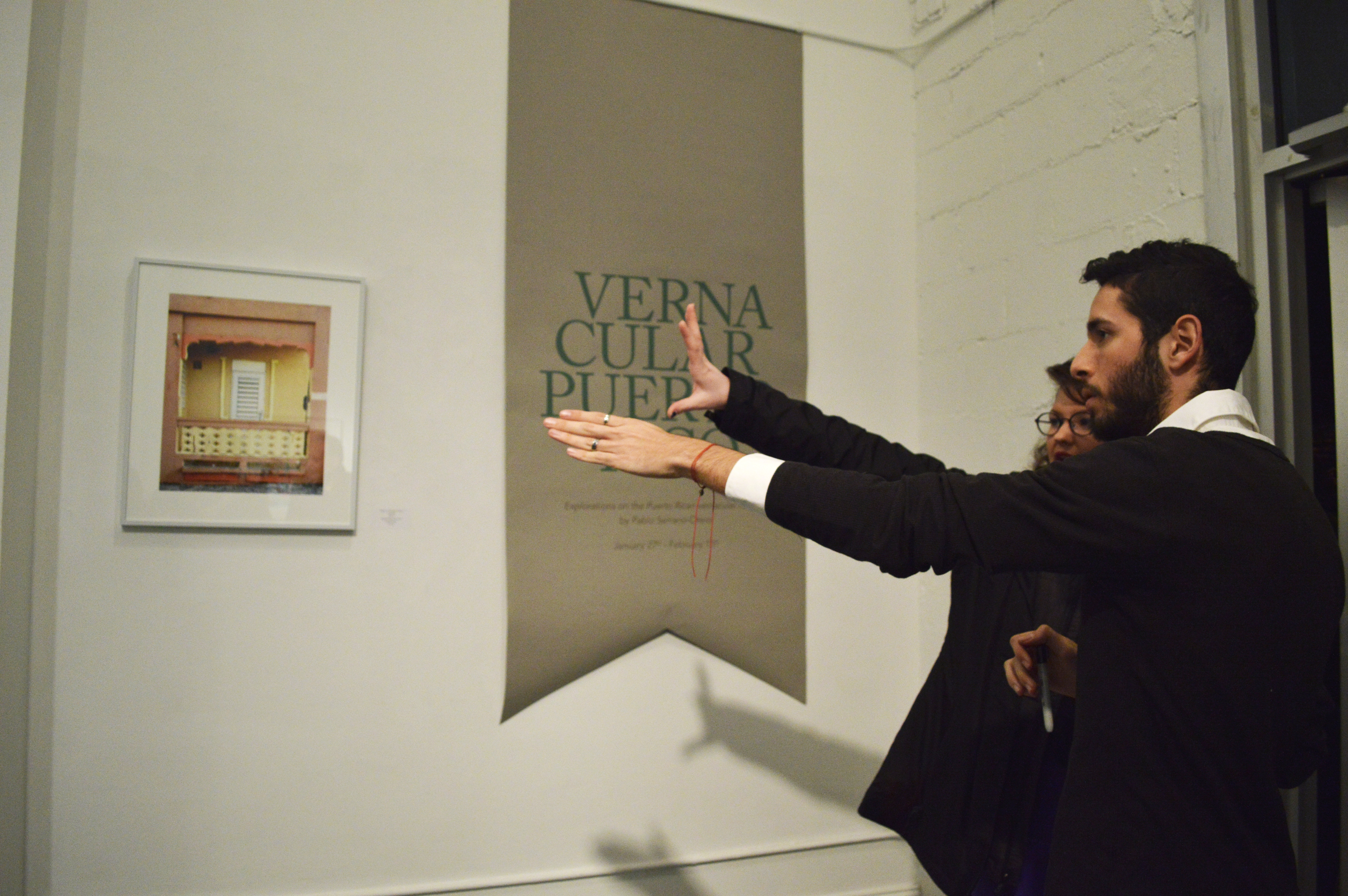 Artist points to his work as he explains it visitor