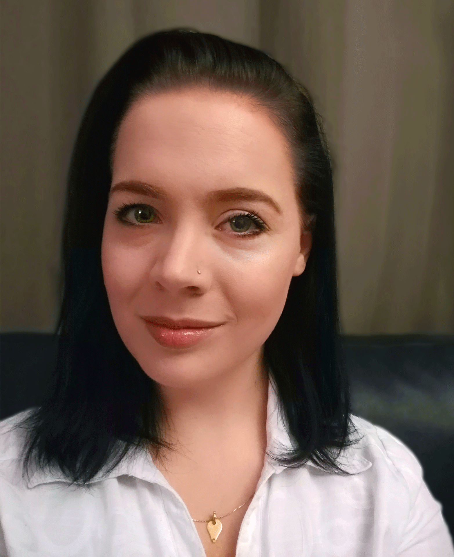 Catlin Scroggie smiles and wears white collar shirt, gold necklace and nose piercing