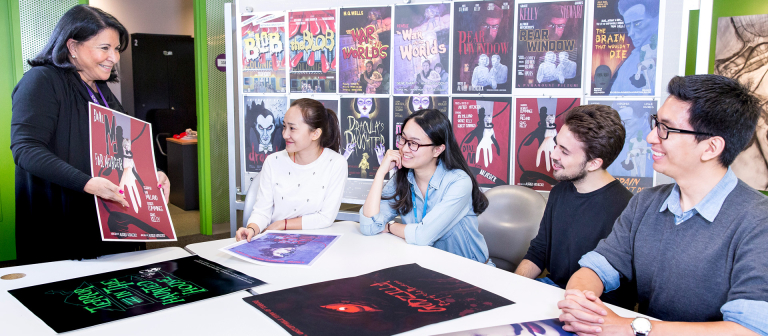 Advertising professor presenting poster designs SCAD professor of advertising showing movie posters to students