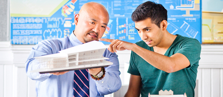 Architecture professor examining model with student